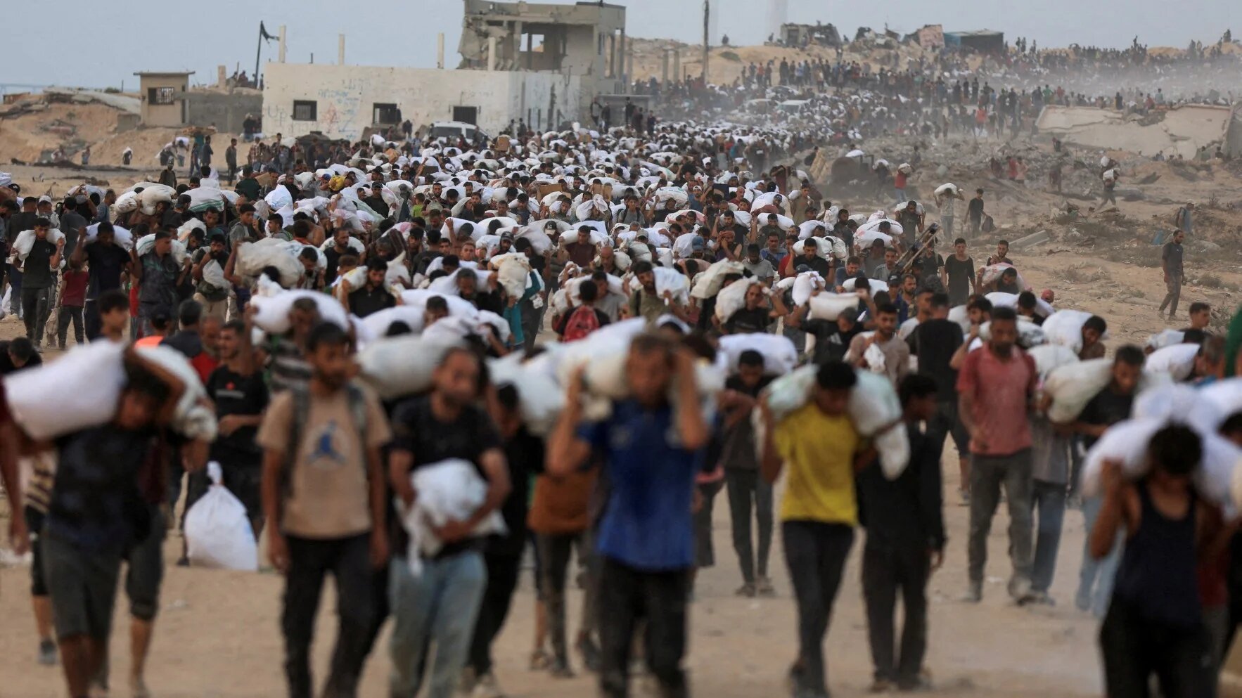Palestinians carry aid supplies, that entered Gaza on trucks through Israel, in Beit Lahia, in the northern Gaza Strip on 29 July, 2025 (Dawoud Abu Alkas/Reuters)