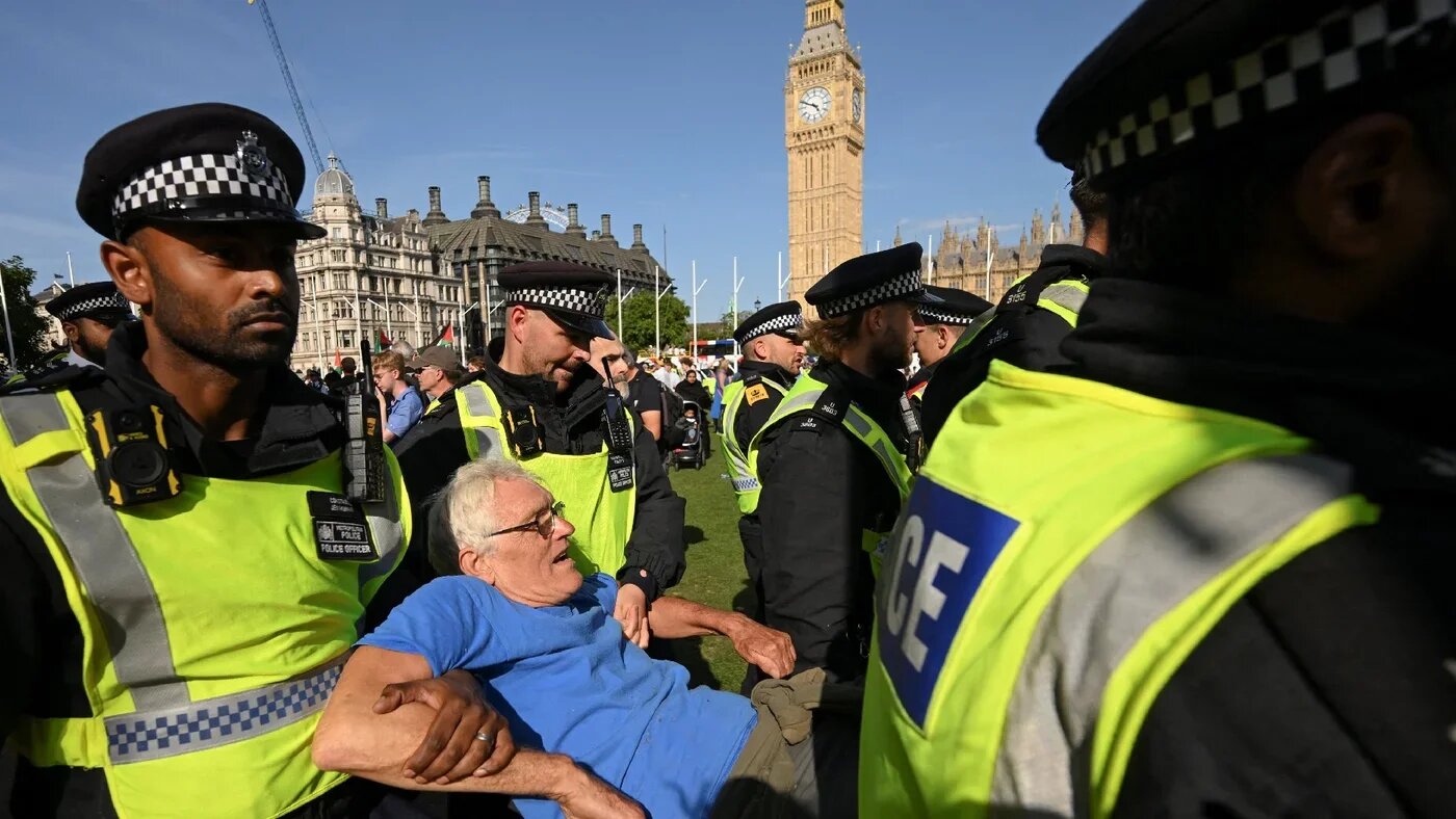 Police officers detain a protester at a rally organised by Defend Our Juries, challenging the British government's proscription of Palestine Action under anti-terrorism laws, in Parliament Square, London on 9 August 2025 (Jaimi Joy/Reuters)