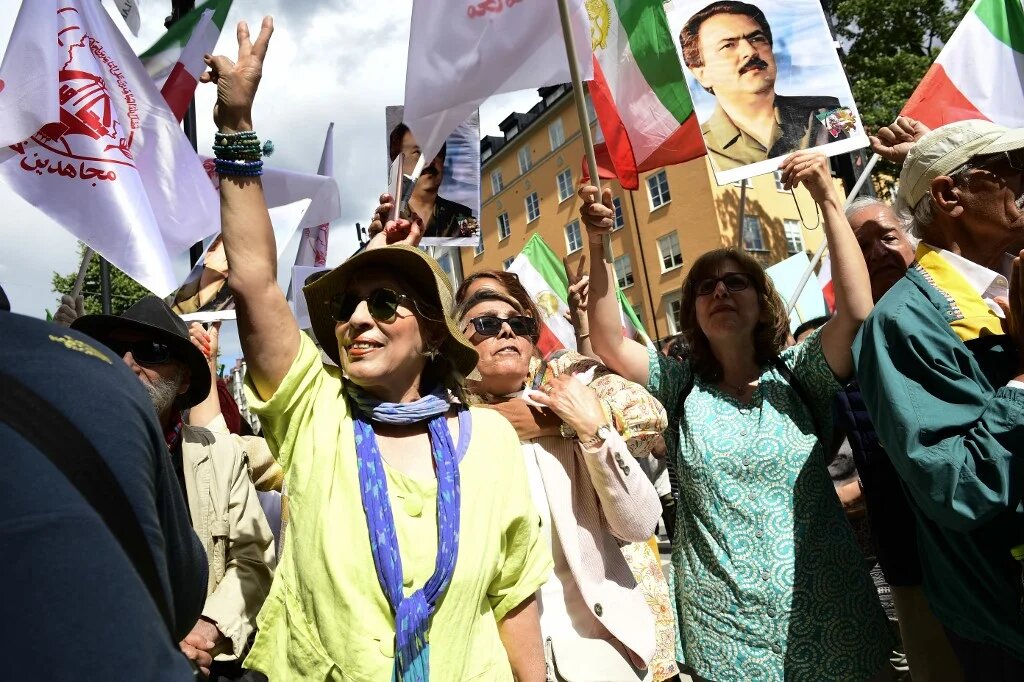 People react outside Stockholm District Court in Stockholm, Sweden, on 14 July 2022, after the life sentence in the war crime trial against Hamid Noury was announced (AFP)
