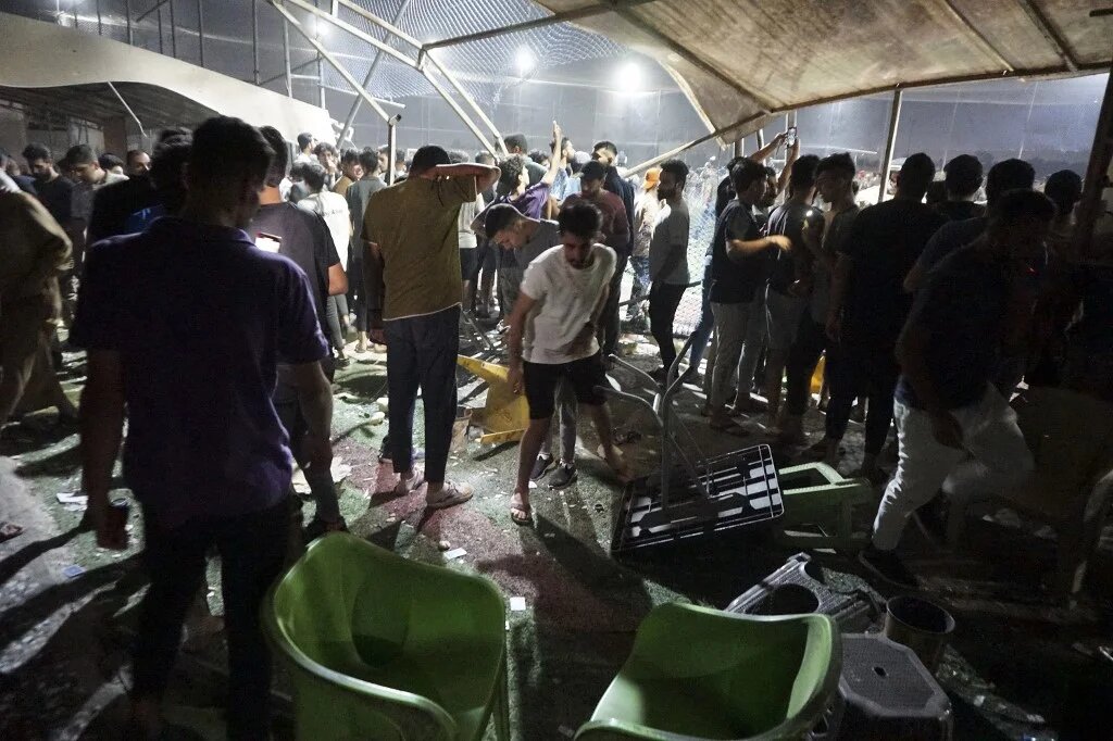Resident look at the damage caused by a gas tanker explosion in Baghdad on 29 October 2022, near a cafe and stadium (AFP)