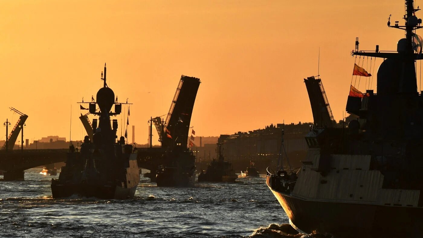 Russian warships sail on the Neva river through raised drawbridges during a rehearsal for the Naval parade in Saint Petersburg early on 16 July 2023 (AFP)