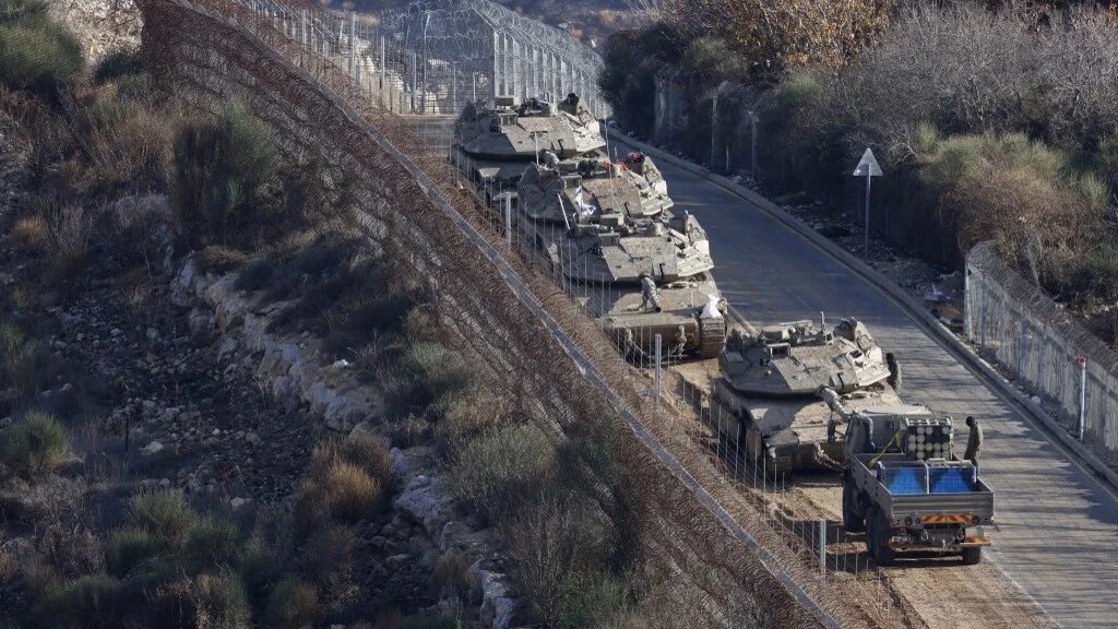 Israeli tanks take position on the border with Syria near the Druze village of Majdal Shams in the Israeli-occupied Golan Heights on 8 December (Jalaa Marey/AFP)