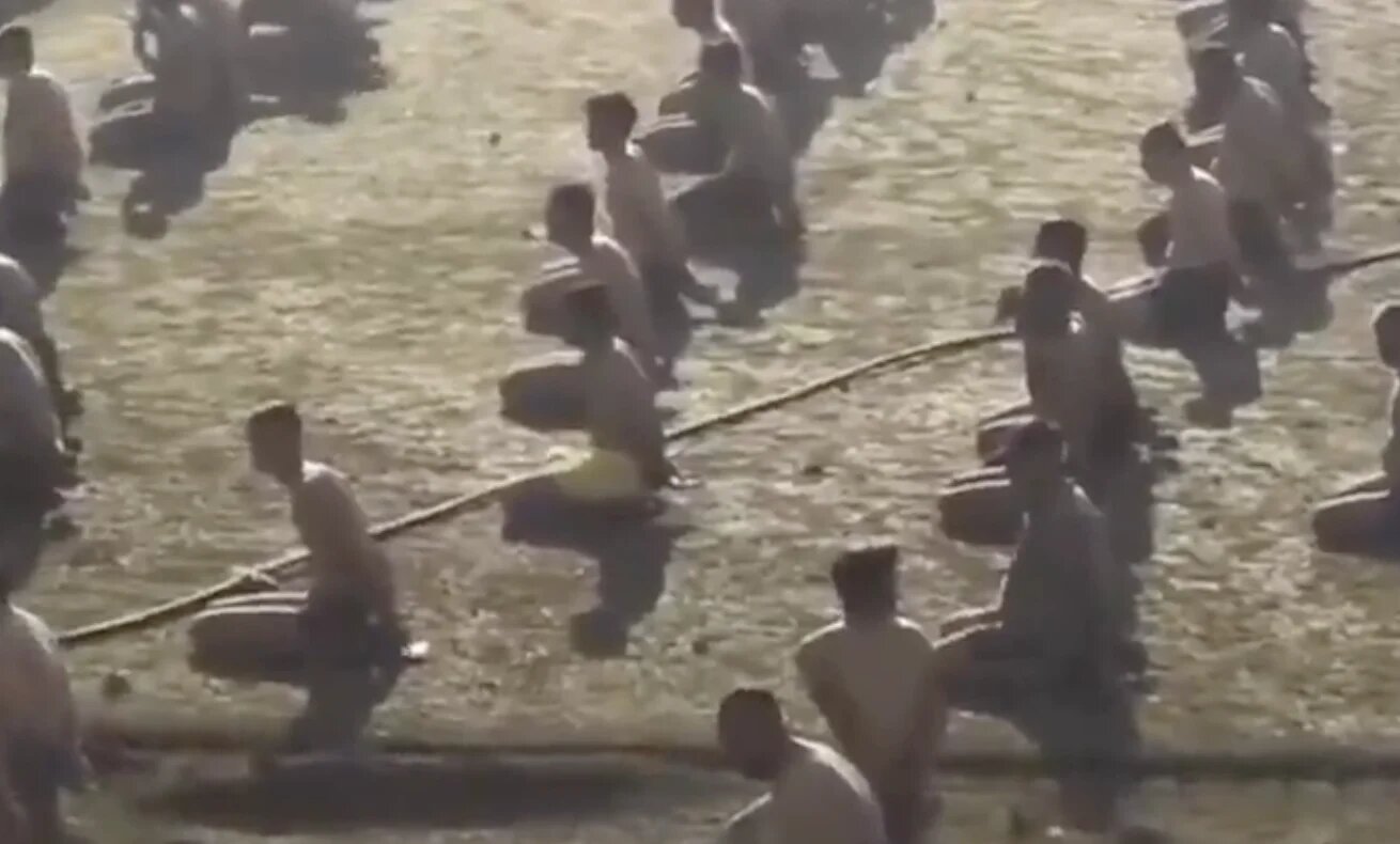 Palestinians are shown rounded up in a stadium after being detained and stripped (Screengrab/X)