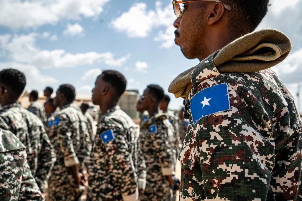 A Somali soldier stands at attention at the General Dhagabadan Training Centre in Mogadishu on 19 March 2024 (Amaury Falt-Brown/AFP)