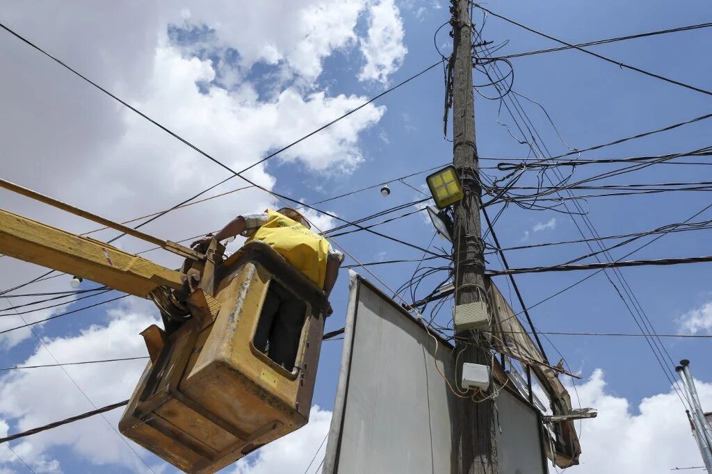 A Syrian electricity company worker carries out maintenance work on power lines in the rebel-held northwestern city of Idlib on June 6, 2021. (Omar Haj Kadour / AFP)