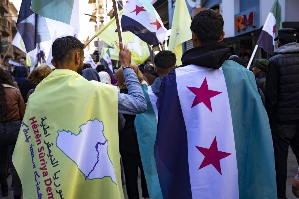 Syrian Kurds wave independence-era flags at a demonstration in support of the US-backed, Kurdish-led Syrian Democratic Forces in Qamishli on December 19 2024.  (Delil Souleiman / AFP)