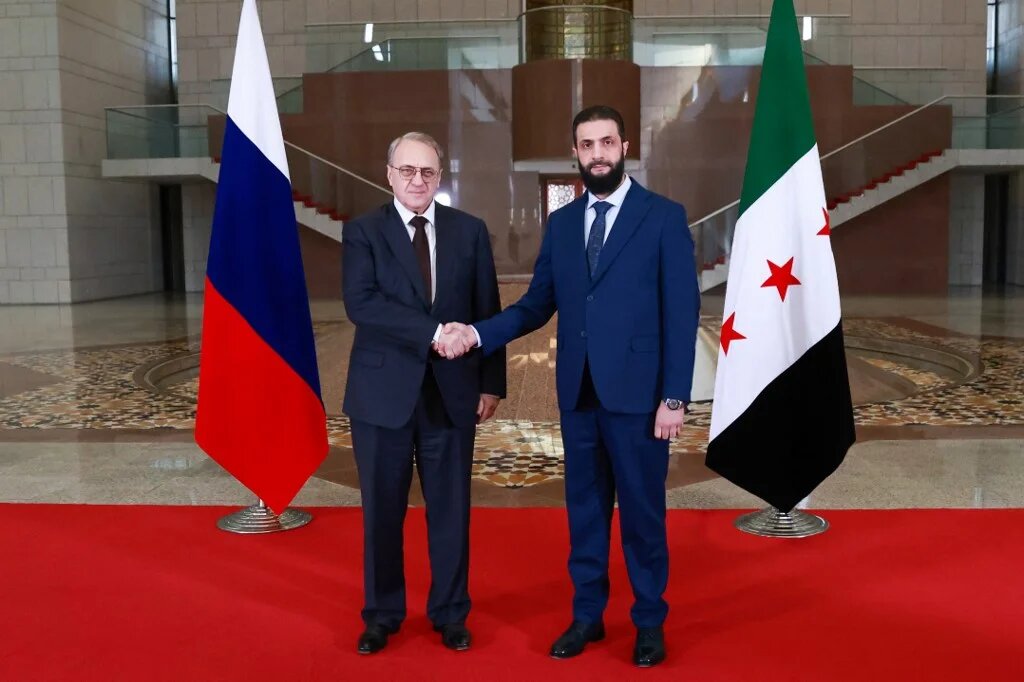 Syria's new leader, Ahmed al-Sharaa (R), and Russian Deputy Foreign Minister Mikhail Bogdanov (L) pose for a photo during their meeting in Damascus in a handout image released on 29 January 2025 (AFP Photo/Syria Transitional Government)
