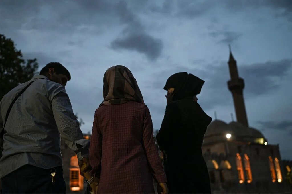A Syrian family walks near Balikligol (or Pool of Abraham, Halil-Ur Rahman Lake), in the southwest of the city center of Sanliurfa on May 17, 2022. (AFP)