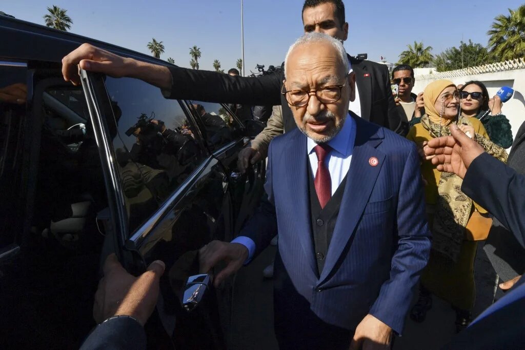The head of Tunisia's opposition party Ennahda Rached Ghannouchi greets supporters upon arrival to a police station in Tunis, on 21 February 2023 (Fethi Belaid/AFP)
