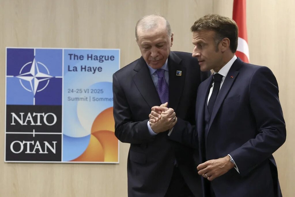 France's President Emmanuel Macron (R) shakes hands with Turkey's President Recep Tayyip Erdogan during their meeting on the sideline of the North Atlantic Treaty Organization (NATO) summit in The Hague on June 25, 2025. (Christian Hartmann / POOL / AFP)
