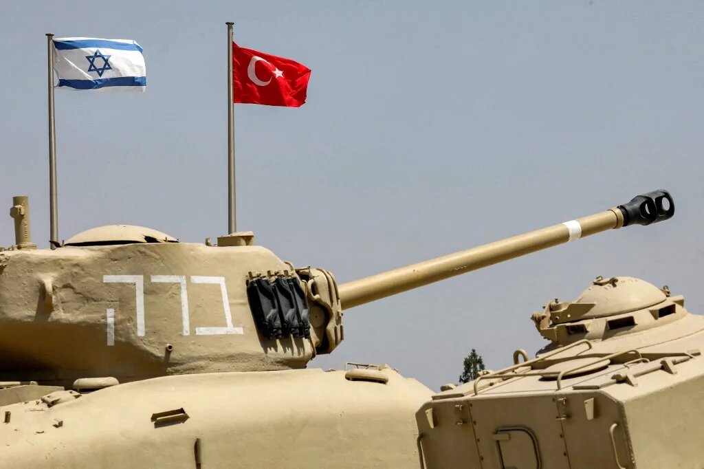 The flags of (L to R) Israel and Turkey fly behind M4A1 Sherman and AMX-13 battle tanks at the Yad La-Shiryon Tank Museum in Latrun, about 30 kilometres west of Jerusalem, on August 18 2022.  (Gil Cohen-Magen / AFP)
