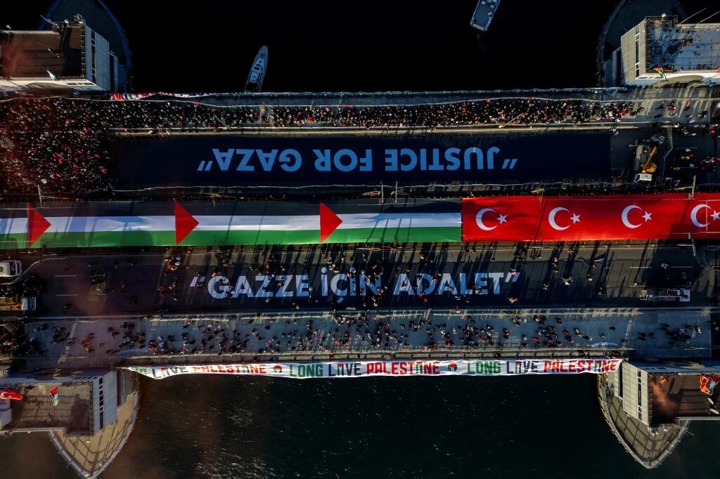 This aerial picture shows thousands of people demonstrating their solidarity with the Palestinian people amid the ongoing war between Israel and the Palestinian Hamas group in the Gaza enclave, at the Galata Bridge in Istanbul on January 1, 2026. (Yasin Akgul / AFP)