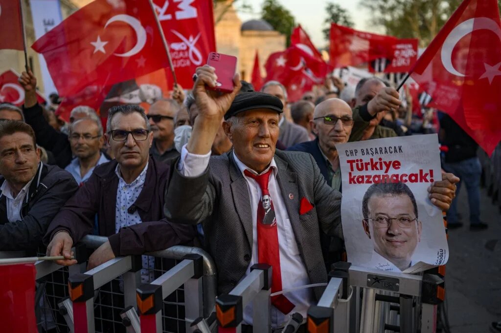 Protesters hold Turkish flags and placards reading 'Freedom for Imamoglu' as they take part in a demonstration against the detention of the Mayor of Istanbul, Ekrem Imamoglu, organised by the country's main opposition, the Republican People's Party (CHP), at Beyazid Square, in Istanbul, 07 May 2025. (Yasin AKGUL / AFP)
