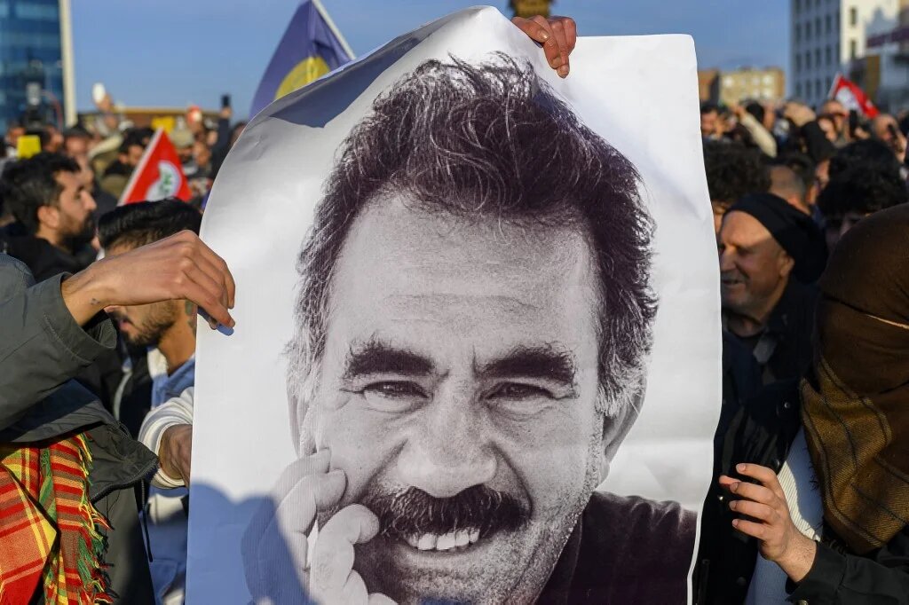 Supporters display a poster of Abdullah Ocalan after he called on the PKK to disarm and dissolve itself in Diyarbakir, southeastern Turkey on 27 February (Yasin Akgul/AFP)