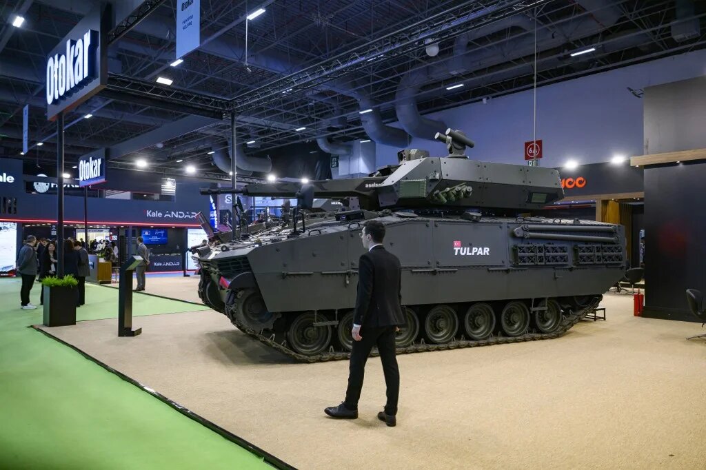 A man walk stand next to a Tulpa Turkish heavy infantry fighting vehicle during the opening day of the SAHA EXPO, an International Defence and Aerospace exhibition, in Istanbul on May 5, 2026. (Yasin AKGUL / AFP)