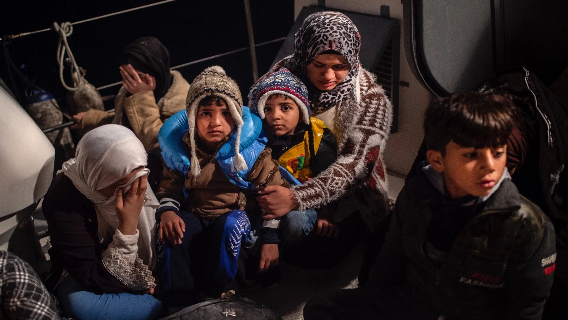Refugees and migrant women and children rest on a Greek Coast Guard ship (Angelos Tzortzinis/AFP)