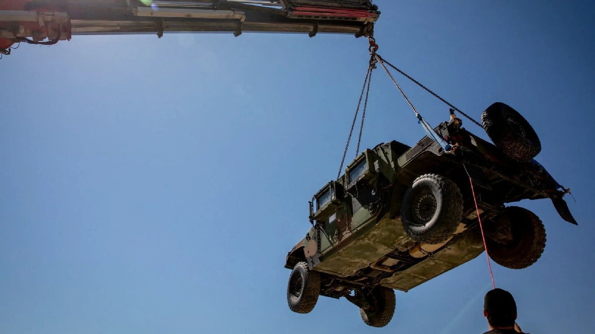 A crane hoists a vehicle at the Logistics Support Area, in a location given as near the Kerem Abu Salem crossing, in this handout picture released 30 June (Board of Peace/Reuters)