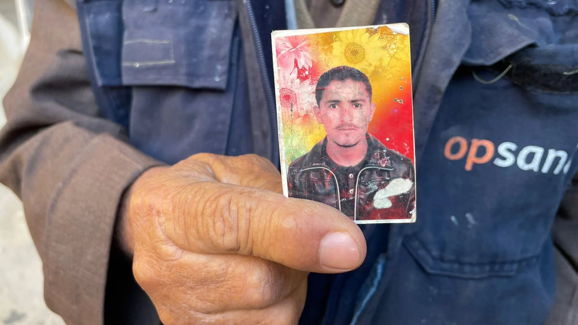 Syrian man Najem Abdullah Jweir displays photo of his missing son at Sednaya prison near Damascus (MEE/Daniel Hilton)