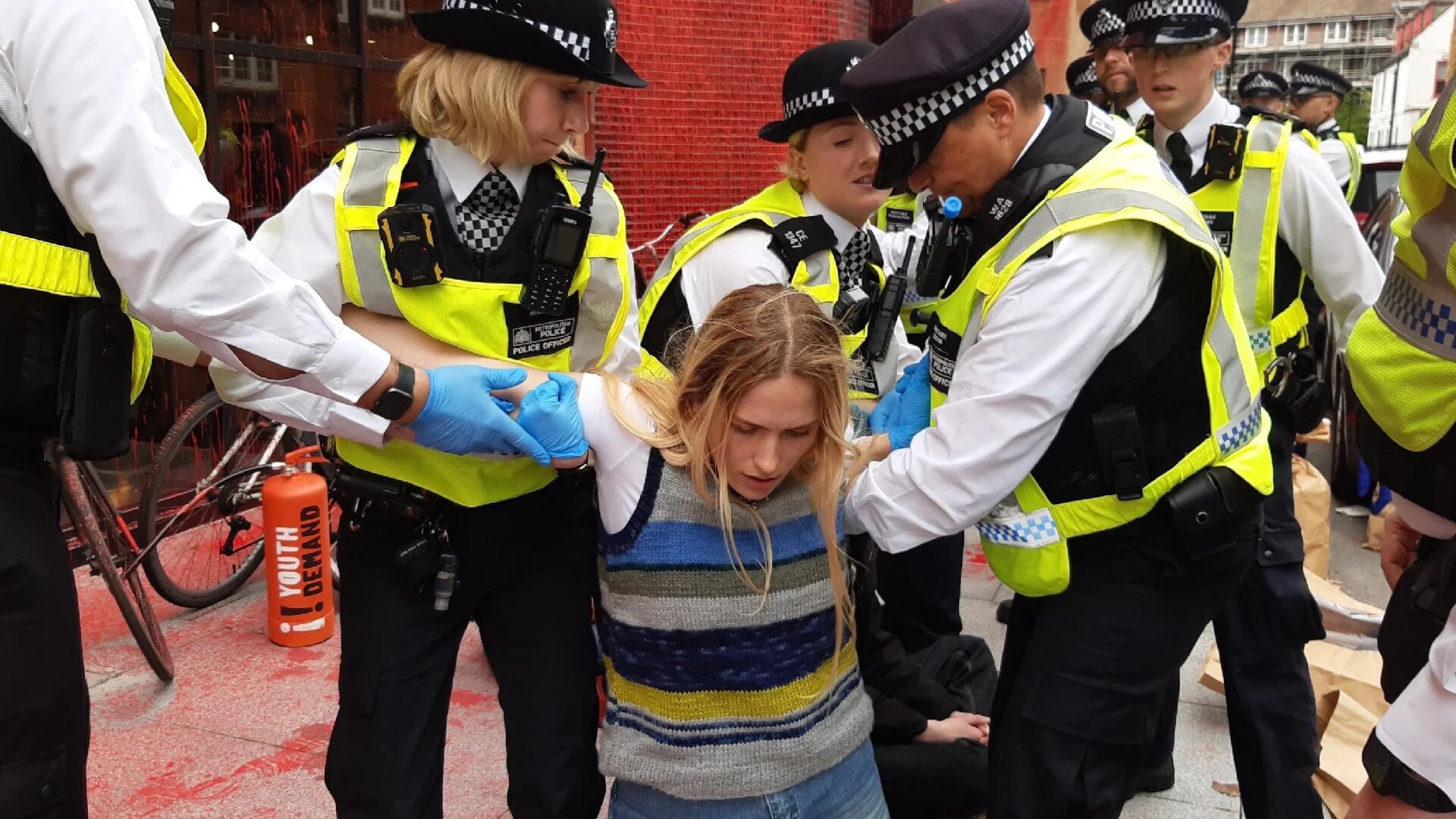 A Youth Demand activist is arrested during a protest outside the Labour Party headquarters on 8 March 2024 (Supplied)