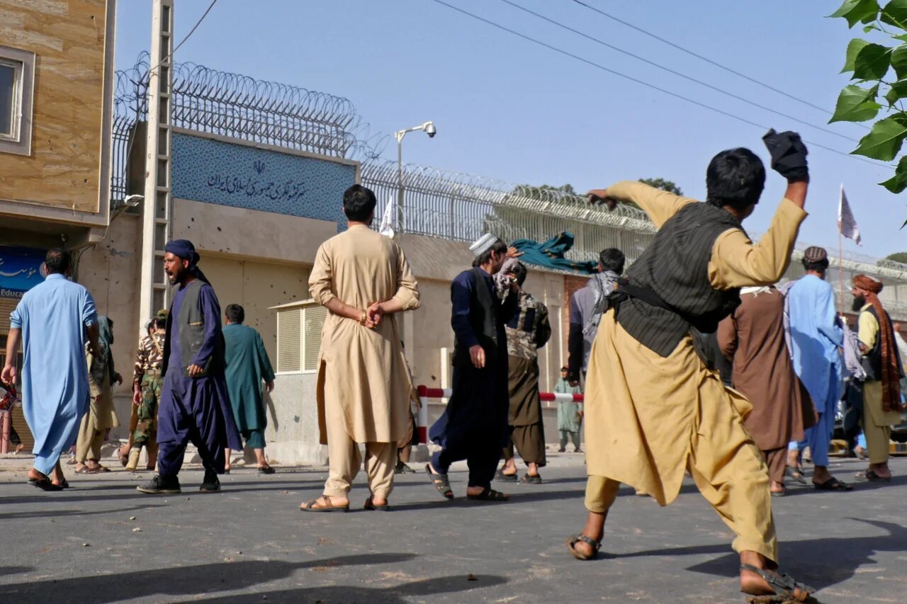 Afghan protesters throw stones at the Iranian consulate in Herat on on 11 April 2022 during a demonstration over reports of harassment of Afghan refugees in Iran (AFP)