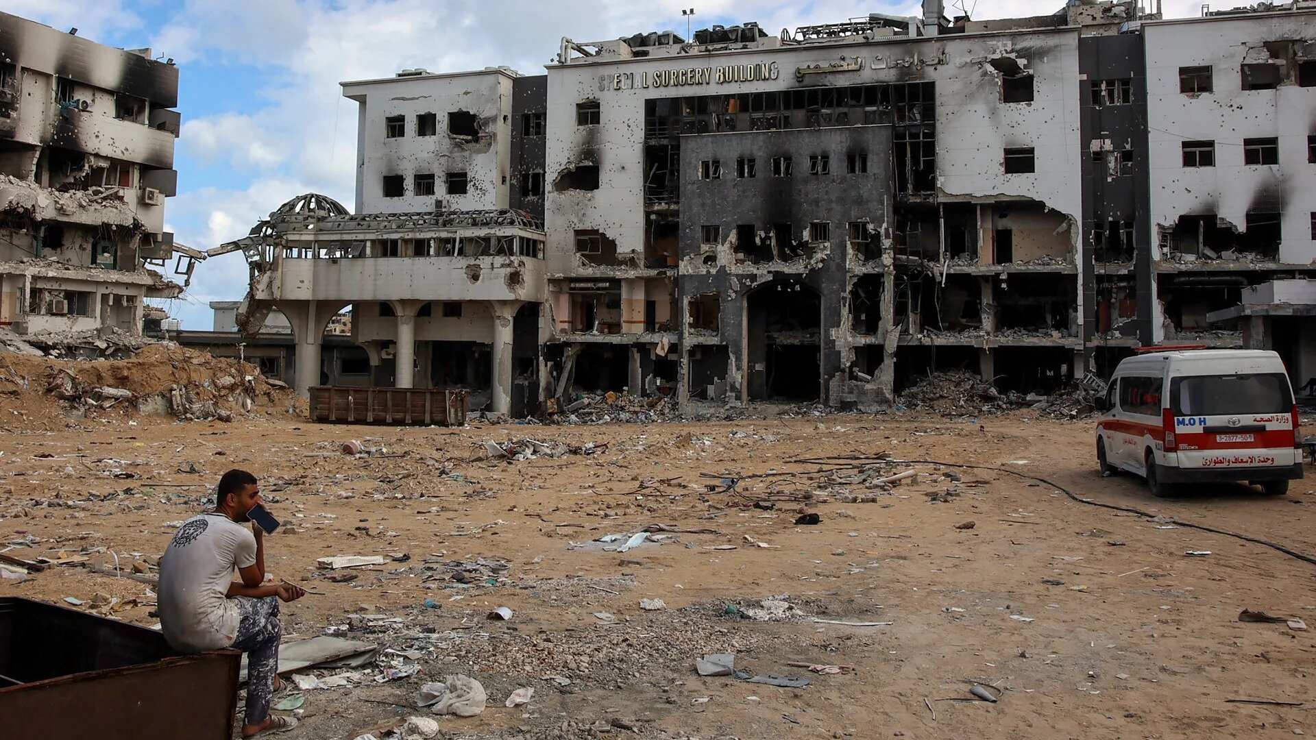 A man sits outside the destroyed al-Shifa Hospital in Gaza City on 17 September 2024 (AFP).