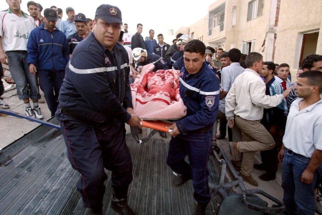 Des pompiers transportent un corps sur une civière à Boumerdès, à 30 km à l’est d’Alger, après un séisme de magnitude 6,8 sur l’échelle de Richter (AFP/Philippe Desmazes)