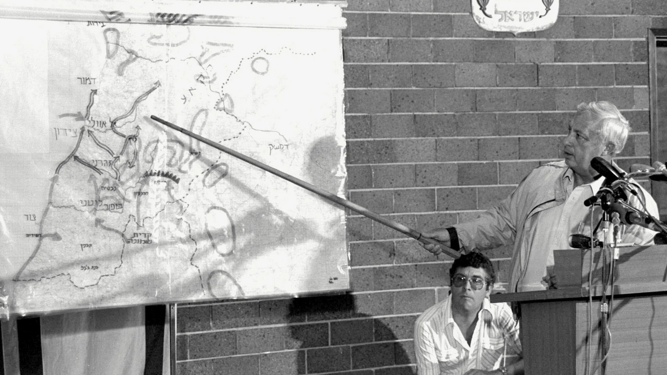 Israeli Defense Minister Ariel Sharon points to a map of Lebanon during a press briefing on the objectives of the military operation "Peace For Galilee" against Lebanon at the Defense Ministry in Tel Aviv, 11 June 1982 (AFP/GPO)