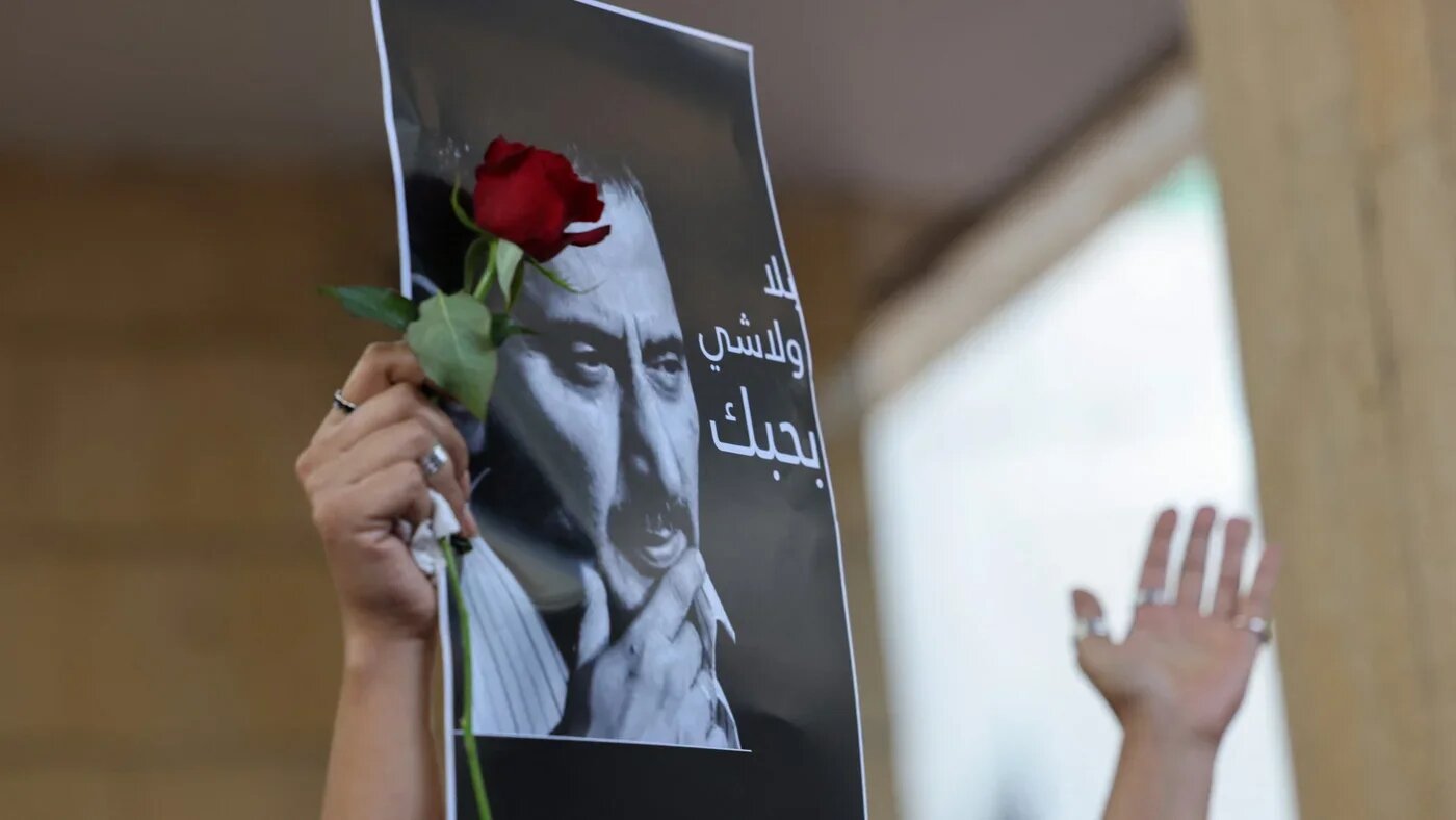 A mourner holds up a rose and a portrait of renowned Lebanese musician and composer Ziad Rahbani as crowds gathered in Beirut to bid him farewell before his funeral procession on 28 July 2025 (AFP)
