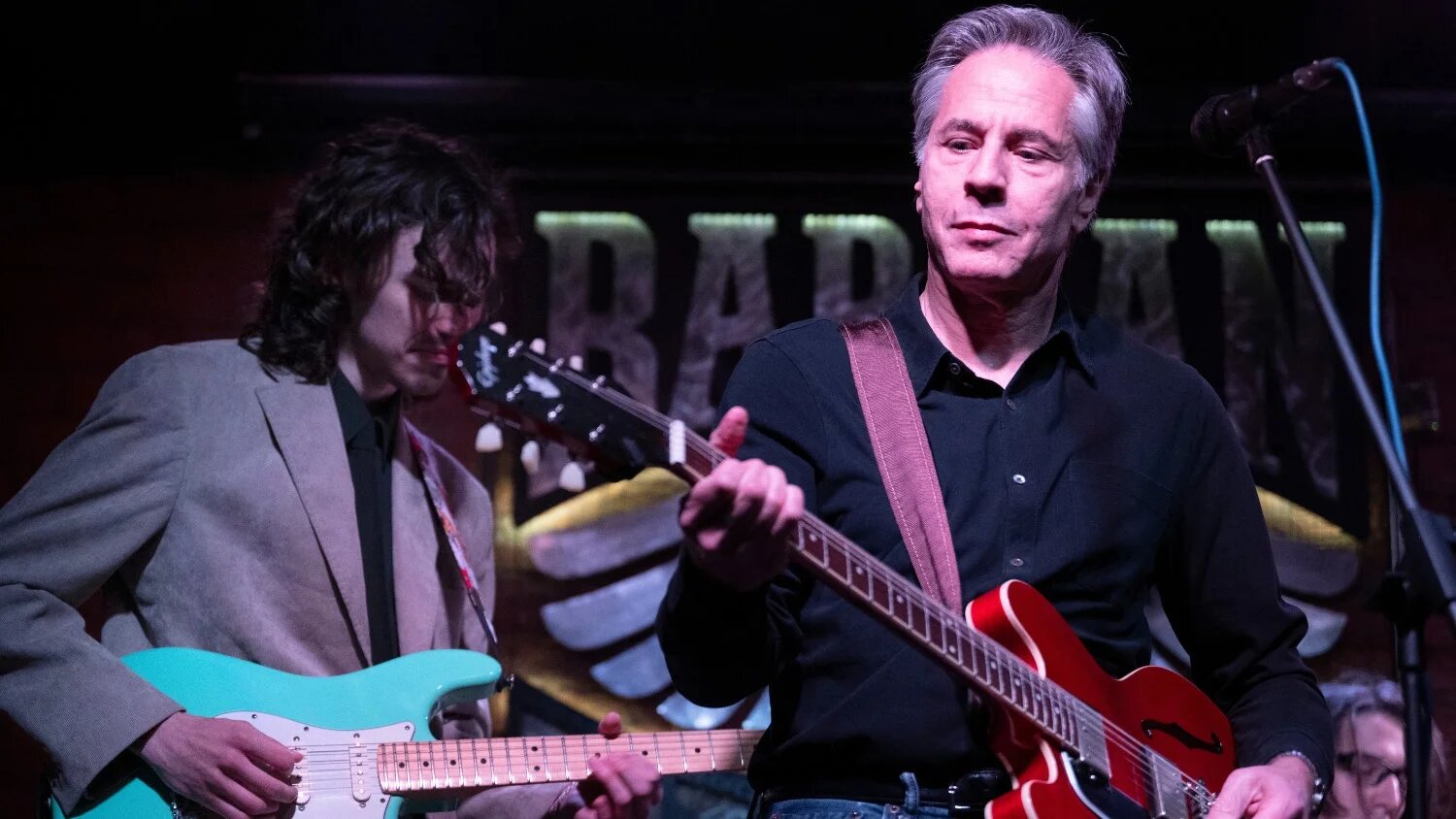  Le secrétaire d’État américain Antony Blinken interprète « Rockin’ in the Free World » avec les membres du groupe The 19.99 au bar Barman Dictat à Kyiv, le 14 mai 2024 (Brendan Smialowski/AFP)