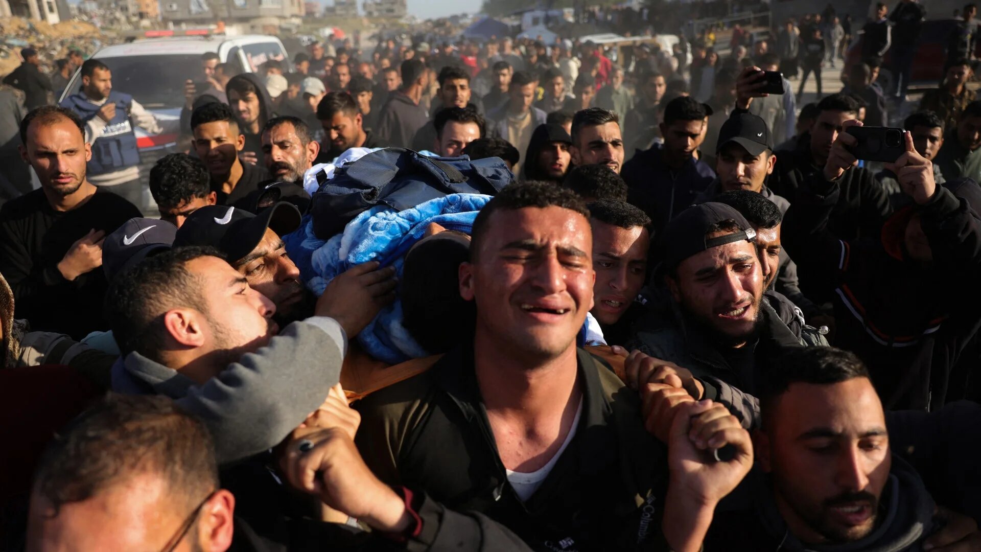 Relatives and colleagues carry the body of Palestinian journalist Hossam Shabat during his funeral in Beit Lahia, in the northern Gaza Strip, on 24 March 2025 (AFP/Bashar Taleb)