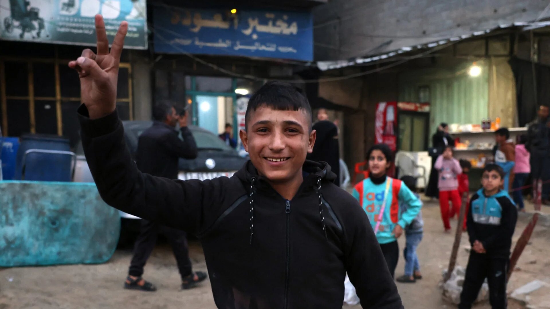 A boy celebrates along a street in Khan Yunis in the southern Gaza Strip on 15 January 2025 (AFP/Bashar Taleb)