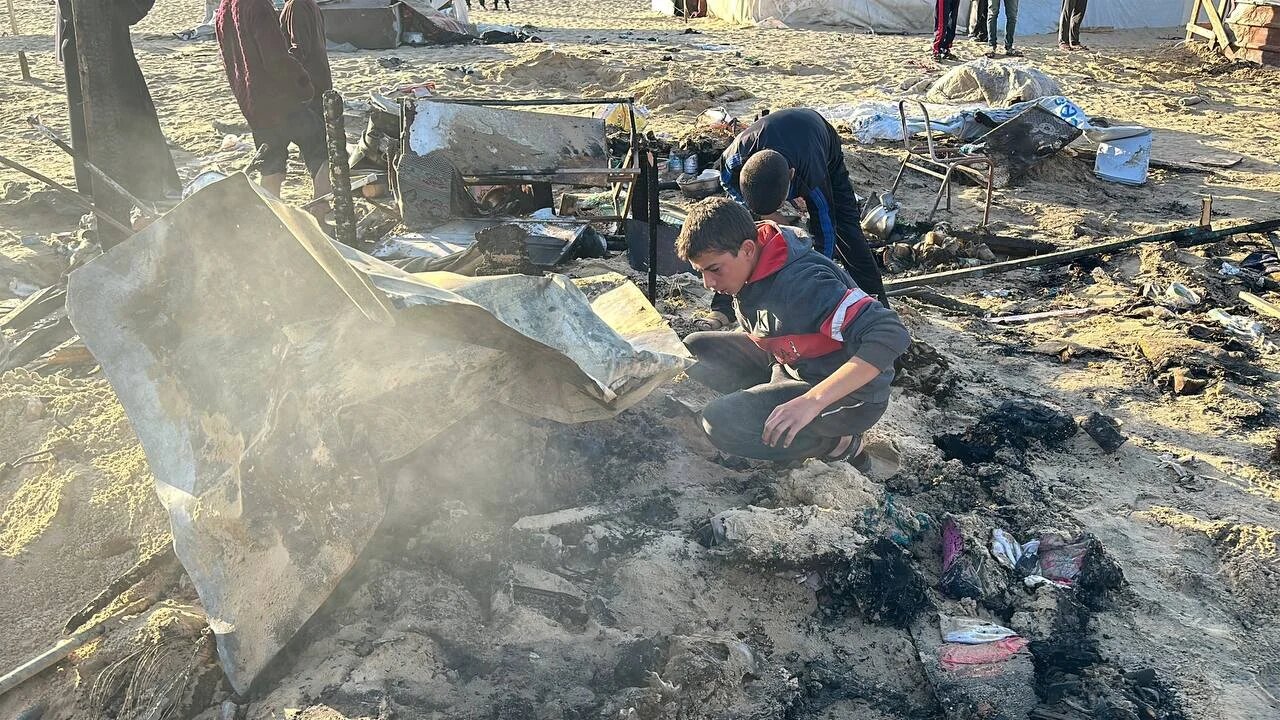 A child searches through the aftermath of an Israeli strike in Khan Younis, southern Gaza (MEE/Ahmed Aziz)