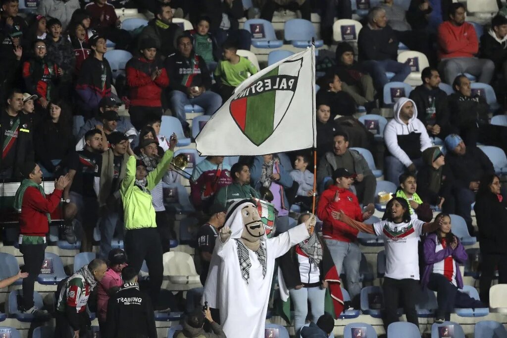Francisco Muñoz applaudit son équipe Palestino portant le costume de la mascotte du club Palestina lors du match de la Copa Sudamericana contre Estudiantes de Merida à Rancagua, Chili, le 18 avril 2023 (AFP/Javier Torres)