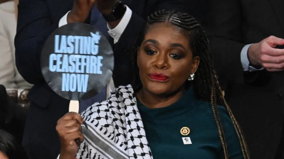 US Representative Cori Bush hold sign reading "Lasting Ceasfire Now" as US President Joe Biden delivers the State of the Union address in the House Chamber of the US Capitol in Washington on 7 March 2024.