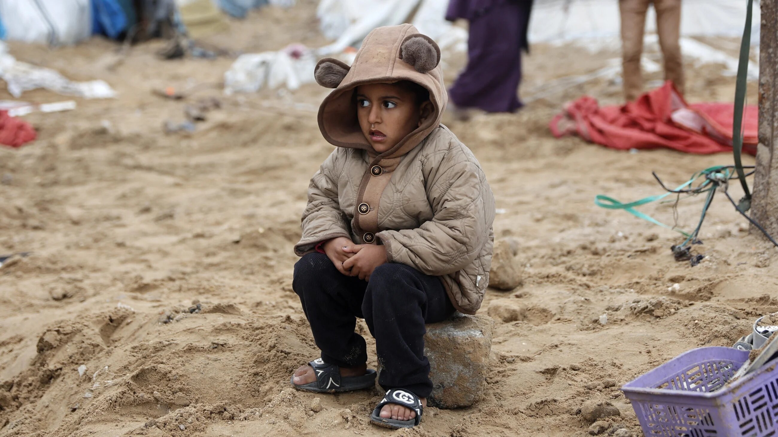 A Palestinian child sits near the aftermath of an Israeli strike on displaced families in Gaza City on 9 January, 2026 (AFP/Omar al-Qattaa)