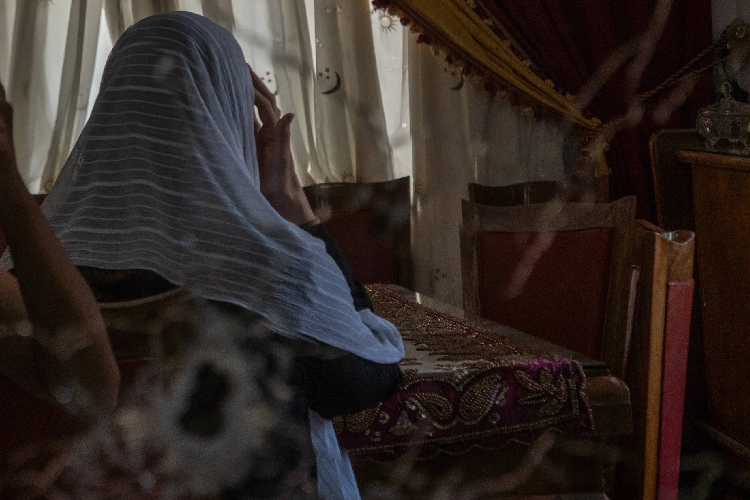 Deema Saraya sits in her house in front of a mirror cracked by a bullet. Her husband was executed, she was a hostage for around eight hours (Anagha Subhash Nair/MEE)