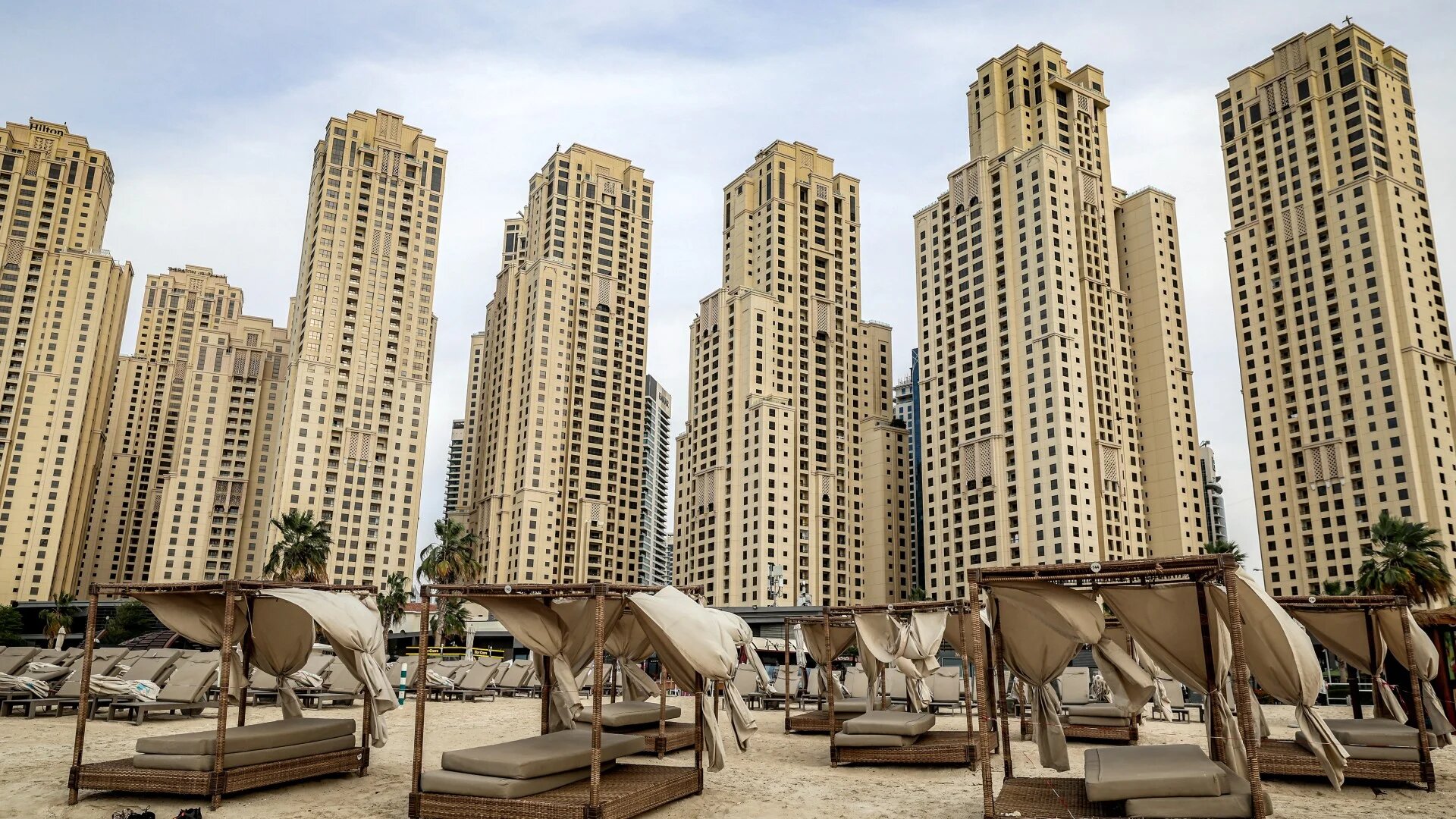 Empty beds are pictured before high-rise buildings along a beach at Jumeirah Beach Residence (JBR) in Dubai on 11 March 2026 (Fadel Senna/AFP)