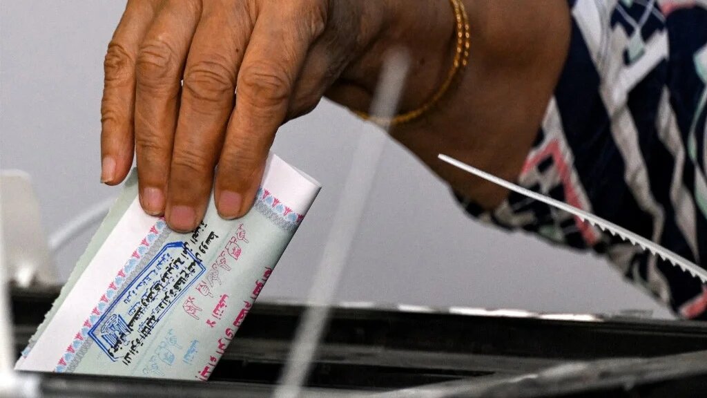 A voter casts a ballot at a polling station in the district of Agouza, in the Egyptian city of Giza, during Senate elections on 4 August 2025 (Khaled Desouki/AFP)