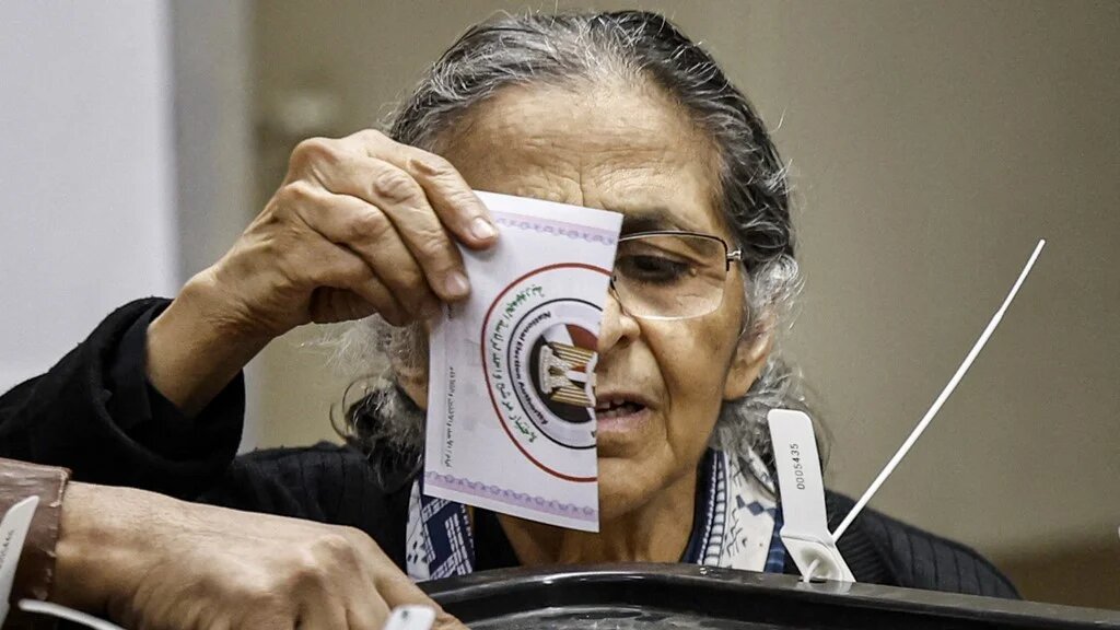 An Egyptian woman casts her vote at a polling station in the Zamalek district of Egypt's capital Cairo during the presidential elections on 11 December 2023 (AFP)