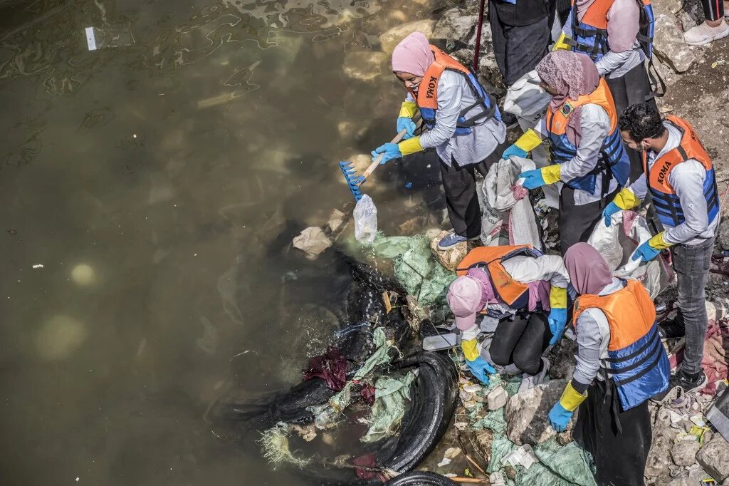 Des volontaires ratissent l’eau du Nil au large de l’île de Manial al-Roda au Caire, le 7 mars 2020, alors qu’ils participent à une campagne de nettoyage des déchets d’eau (AFP/Khaled Desouki)