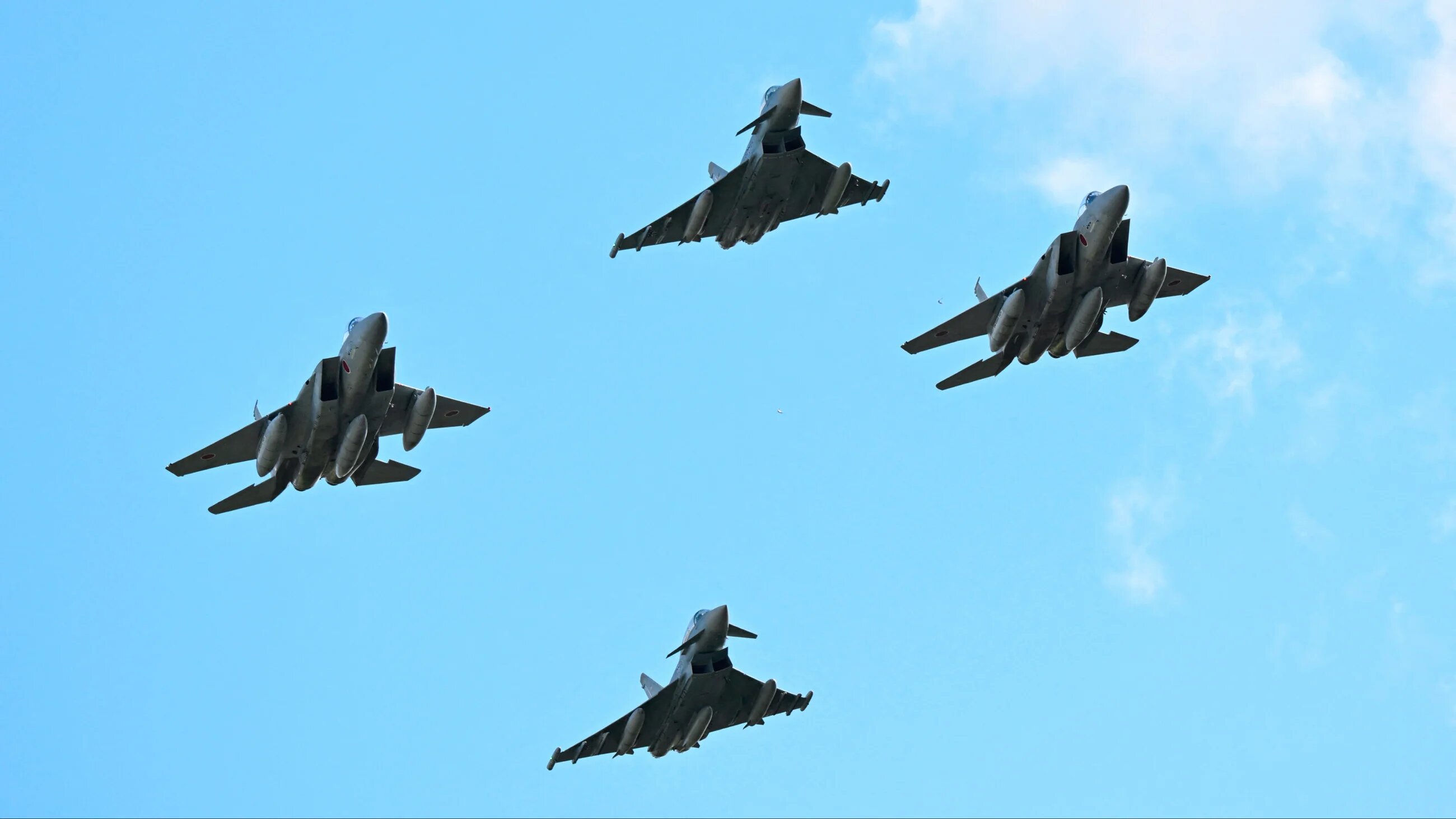 Eurofighter Typhoon (top and bottom) and Japanese Air Self-Defence Force F-15 fighter jets fly over the military air base in Laage, northeastern Germany on 23 September 2025 (AFP)