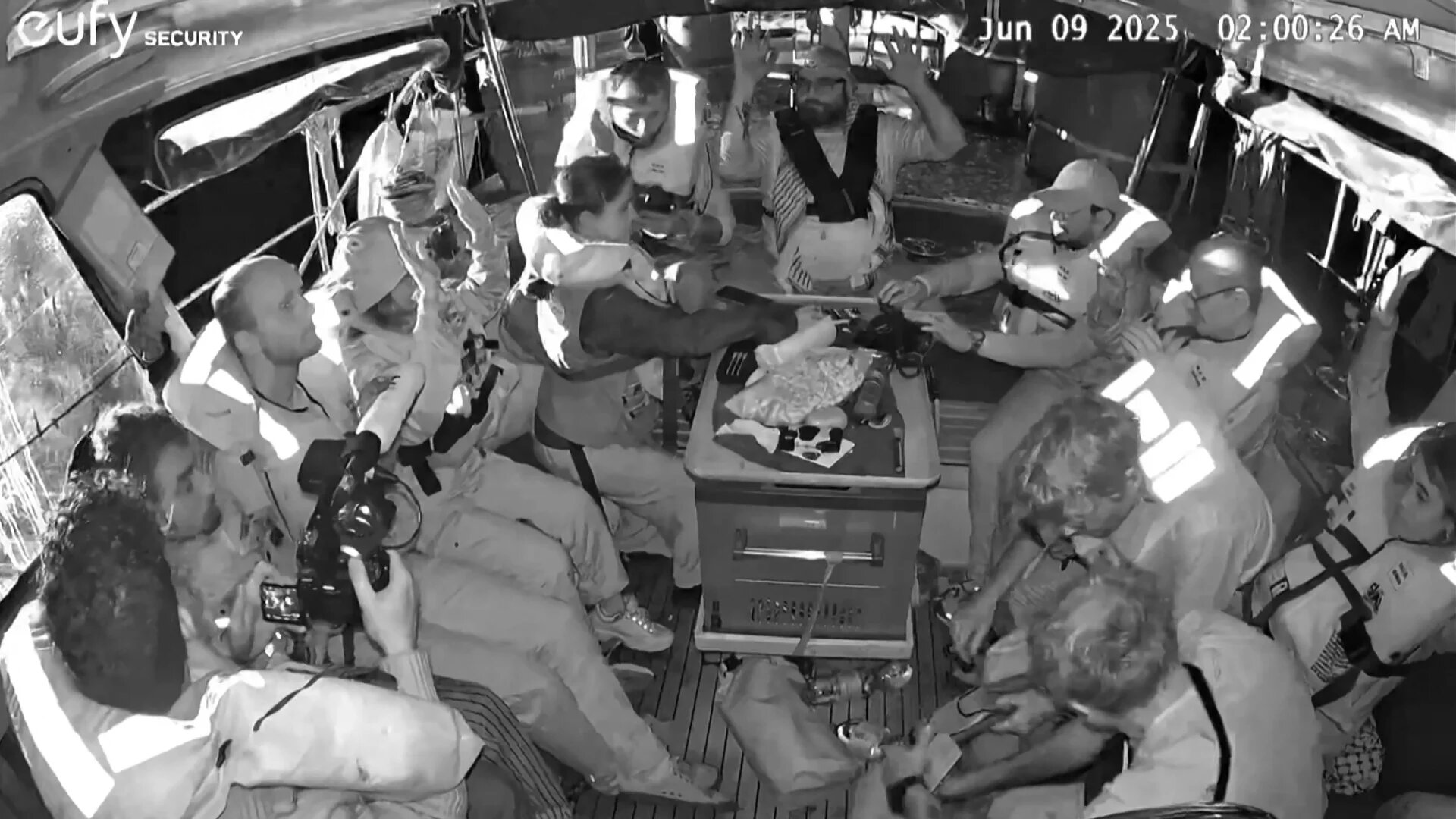 An image grab from 9 June 2025 shows activists on board the Gaza-bound aid boat Madleen, with their hands in the air, as they are being intercepted by Israeli forces in international waters (AFP/Freedom Flotilla Coalition)