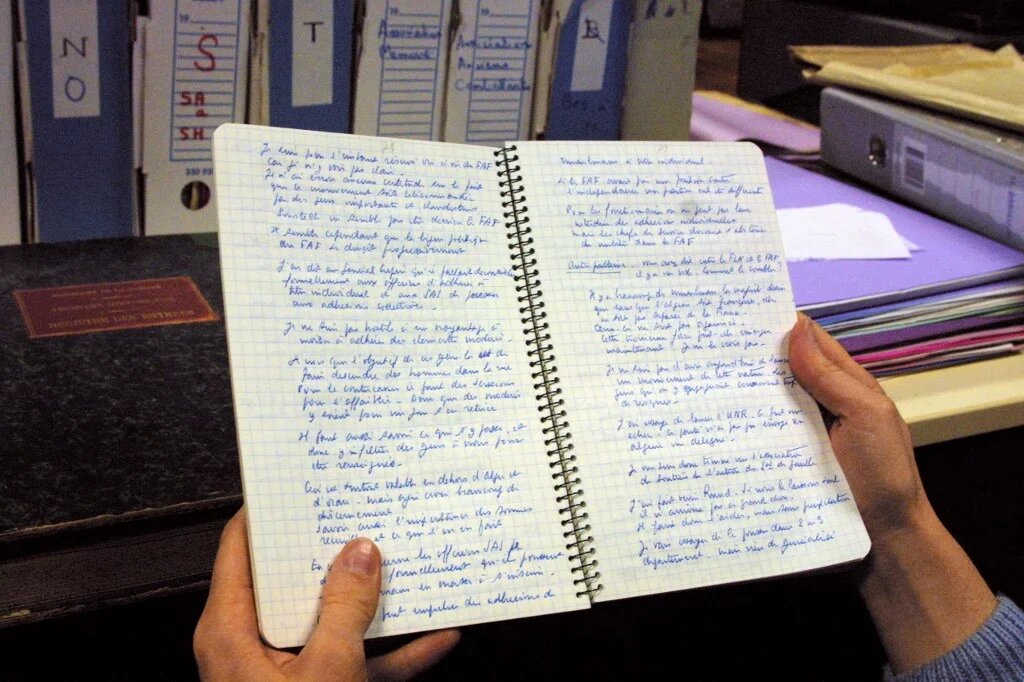 Une personne consulte, le 29 octobre 2001, dans une salle du Service historique de l’armée de terre au château de Vincennes, un des carnets de notes écrits pendant la guerre d’Algérie par le préfet Jean Vaujour, directeur de la sûreté générale en Algérie au début du conflit (AFP/Daniel Janin)