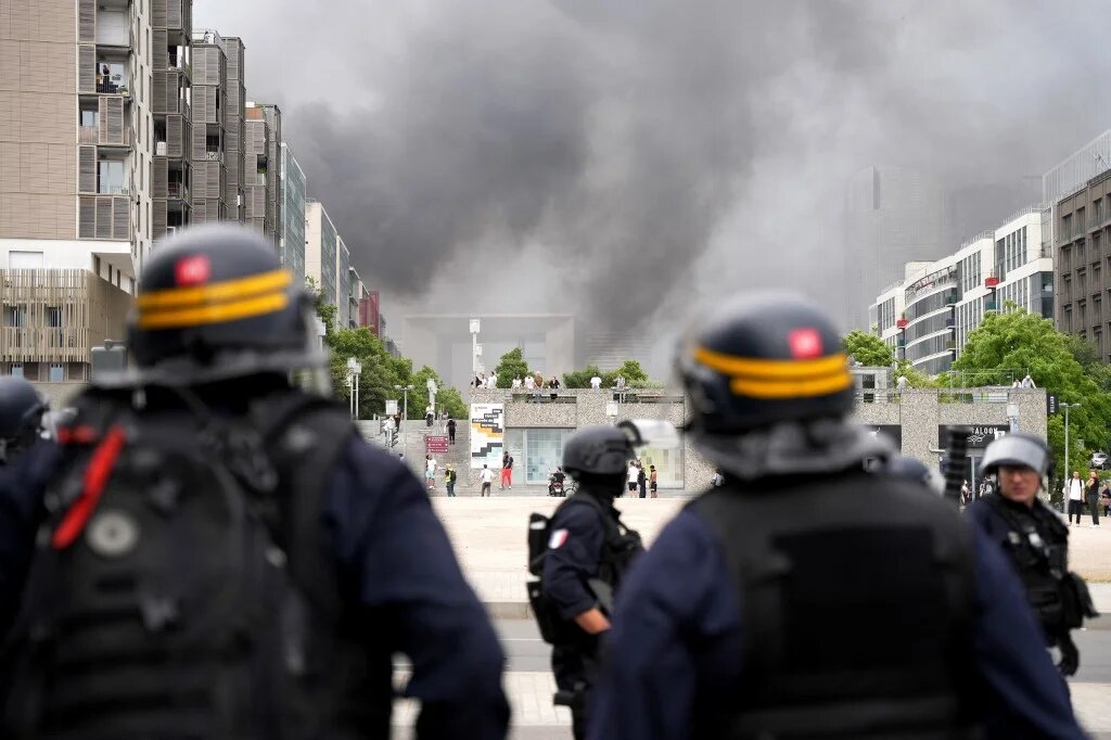 Des CRS font face à des manifestants dans le quartier de La Défense à Paris à l’issue d’une marche de commémoration pour Nahel, adolescent abattu par un policier le 27 juin 2023 à Nanterre, en banlieue parisienne, deux jours après sa mort (AFP/Zakaria Abdelkafi)