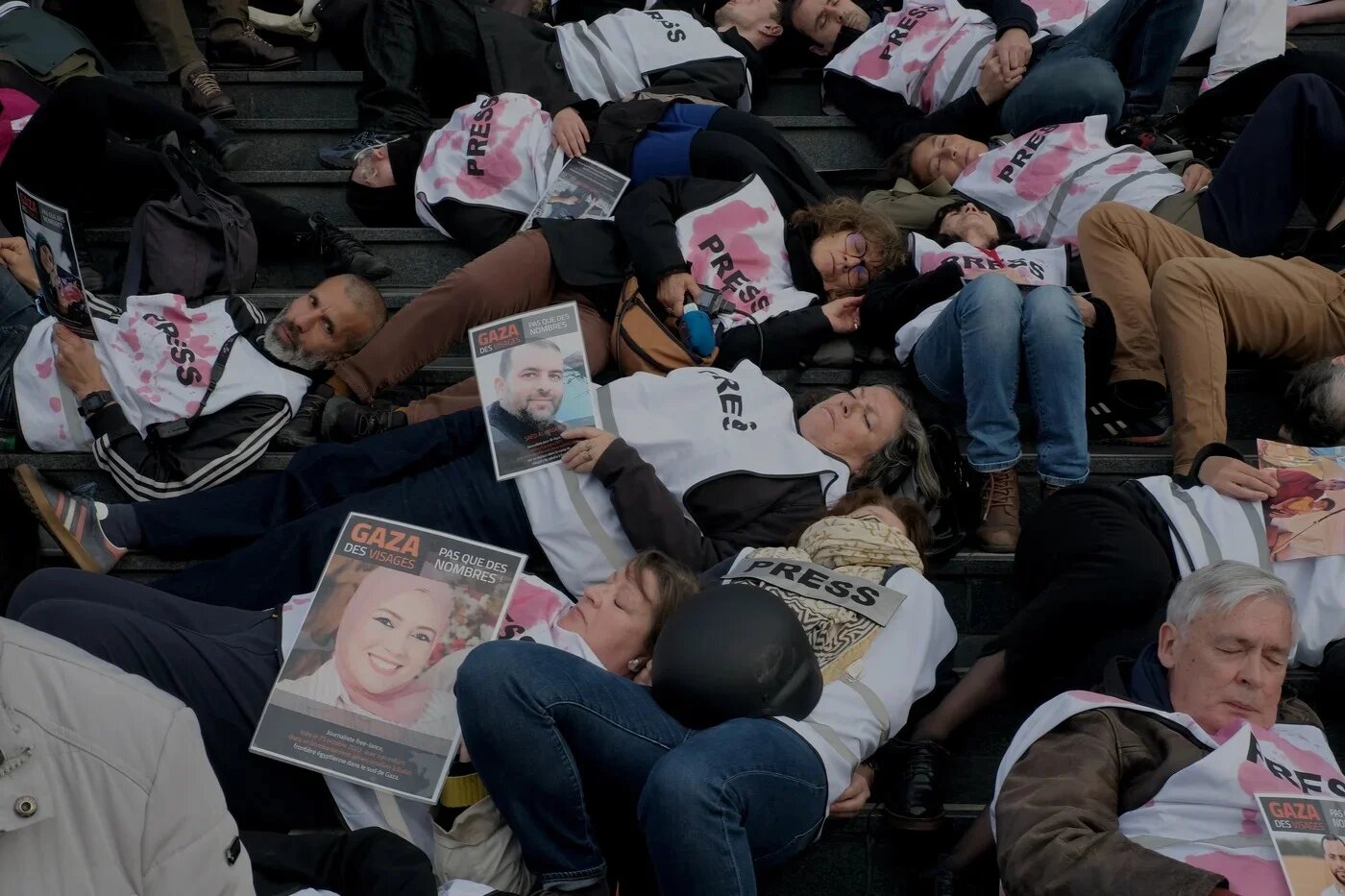 Protesters wearing jerseys reading "press" stage a die-in during a demonstration in support of Palestinian journalists in front of the Opera Bastille in Paris, on 16 April (Bilge Kotan/MEE)