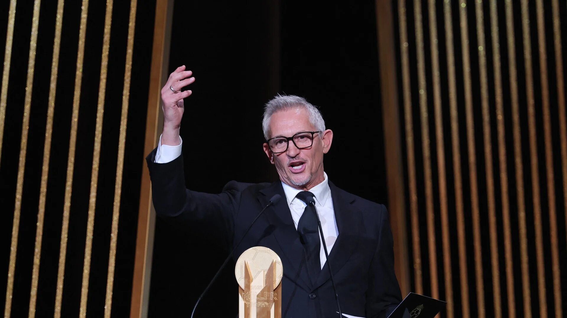 Gary Lineker, former England footballer turned sports TV presenter, gestures on stage with the Gerd Muller Trophy for best striker during the 2023 Ballon d'Or France Football award ceremony at the Theatre du Chatelet in Paris on October 30, 2023. FRANCK FIFE / AFP