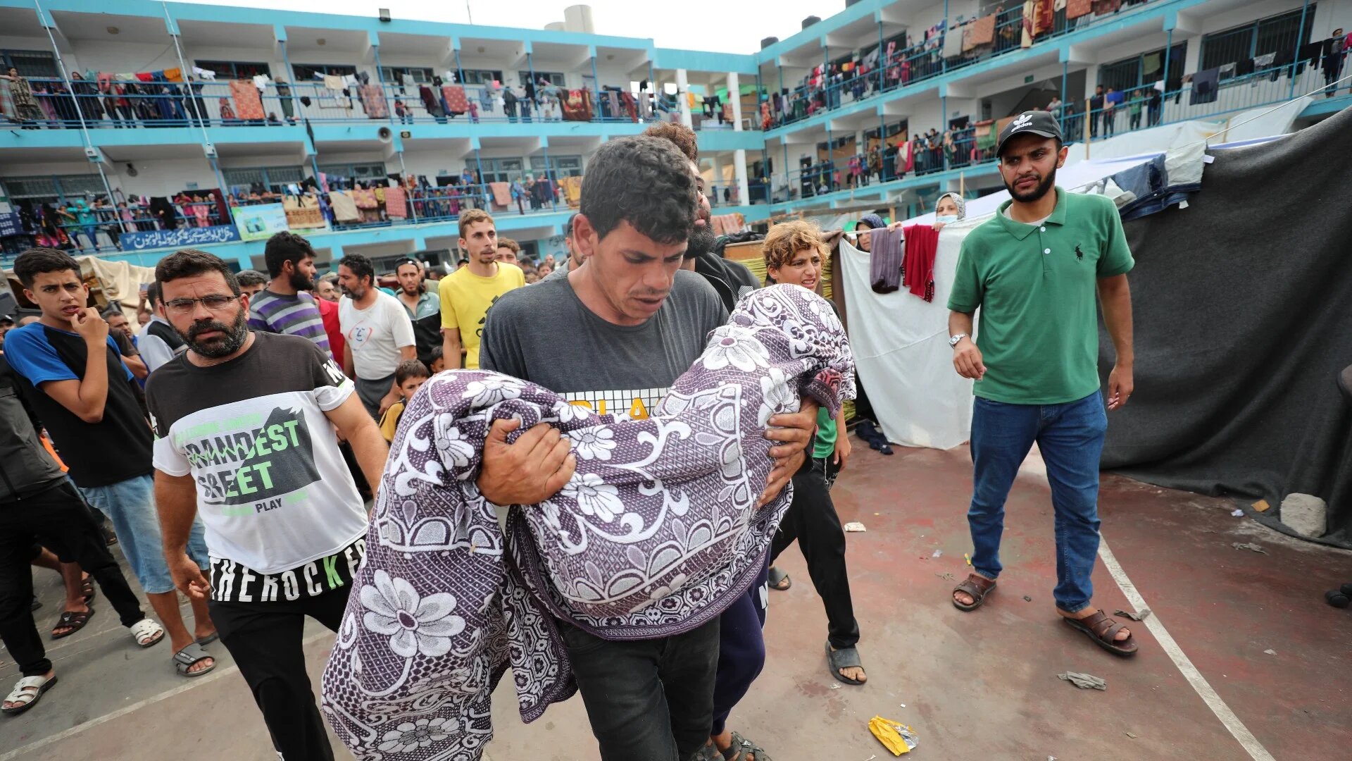 Palestinians carry a child killed in the Israeli bombardment of the Gaza Strip during his funeral at a UN-run school in Deir al Balah, Gaza Strip, Friday, 27 October 2023 (AP)