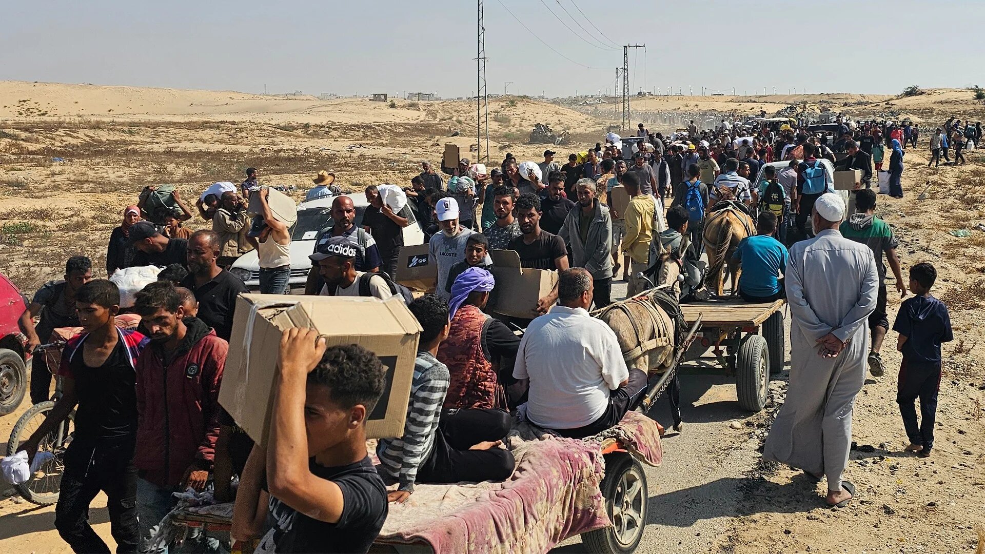 Displaced Palestinians walk along a road to receive humanitarian aid packages from a US-backed foundation in Rafah in the southern Gaza Strip on 5 June 2025 (AFP)