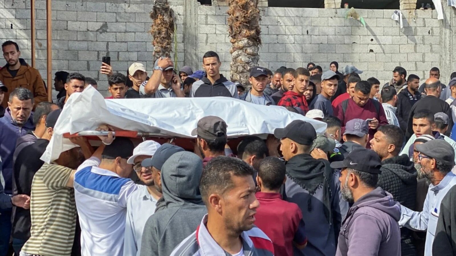 Palestinians carry the body of a casualty of Israeli strikes ahead of burial, at the Nasser hospital in Khan Younis in southern Gaza on 15 May 2025 (AFP)