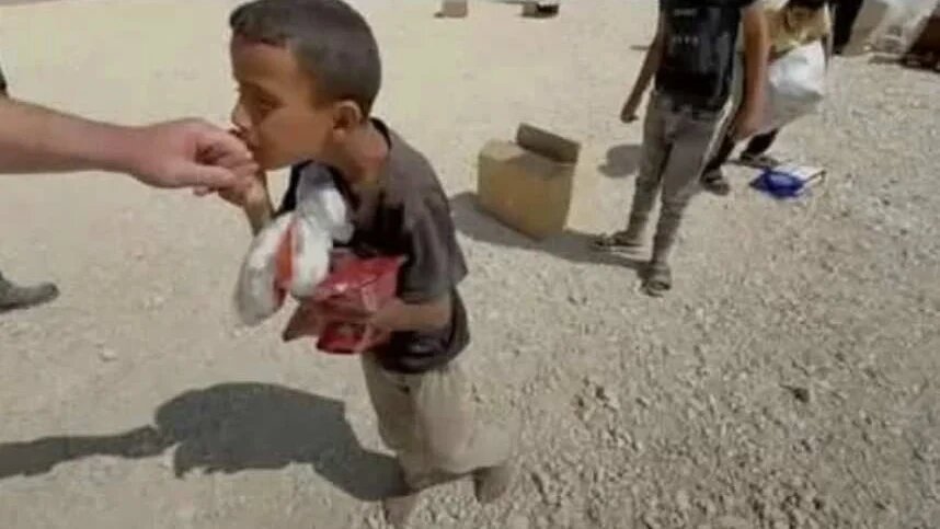 In this photo, Amir can be seen kissing the hand of former US contractor Anthony Aguilar in southern Gaza on 28 May 2025 (Screengrab)